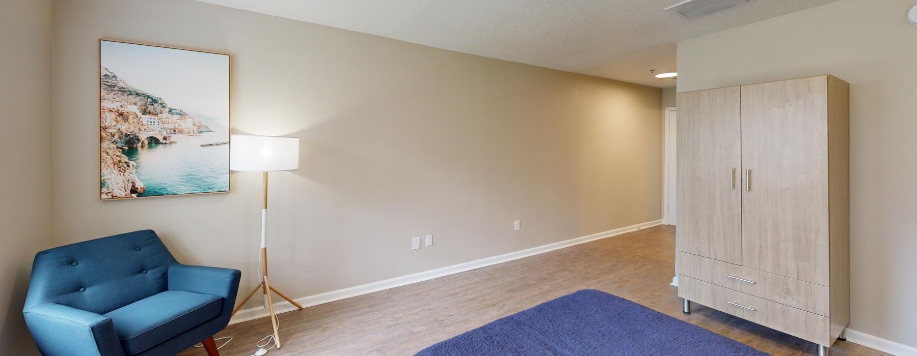 a room with a blue couch and a painting on the wall