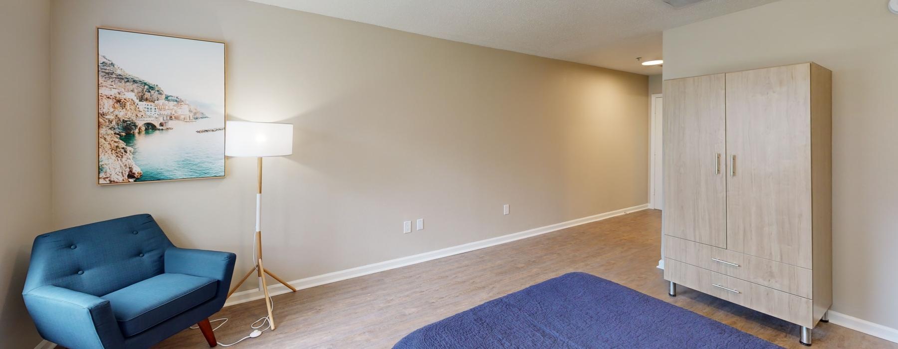 a room with a blue couch and a painting on the wall